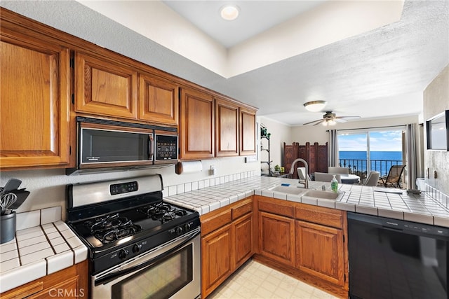 kitchen featuring brown cabinets, a sink, and black appliances