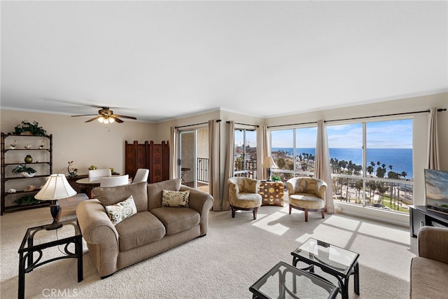 living room with carpet floors, a ceiling fan, and crown molding