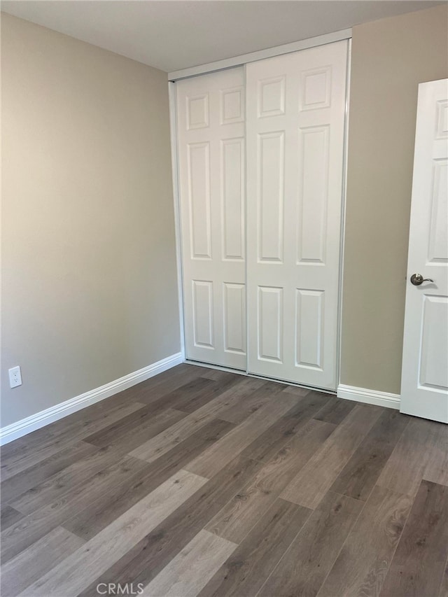 5912 Santa Ana Ave, Riverside, CA 92505 - unfurnished bedroom featuring dark wood-type flooring, a closet, and baseboards