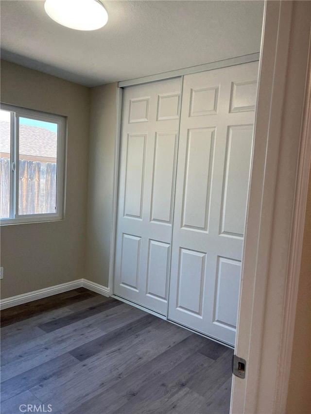 5912 Santa Ana Ave, Riverside, CA 92505 - unfurnished bedroom with baseboards, dark wood-style flooring, and a closet