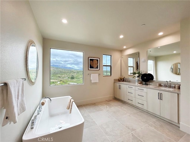 128 Mossvine, Irvine, CA 92618 - full bathroom featuring double vanity, baseboards, recessed lighting, a freestanding bath, and a sink