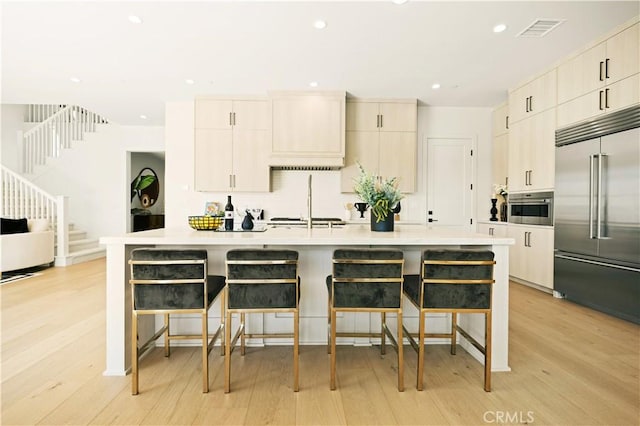128 Mossvine, Irvine, CA 92618 - kitchen with light countertops, a breakfast bar area, stainless steel appliances, and visible vents