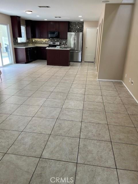 11433 Mountain View Dr Unit 62, Rancho Cucamonga, CA 91730 - kitchen with stainless steel appliances, tasteful backsplash, light tile patterned floors, and a kitchen island