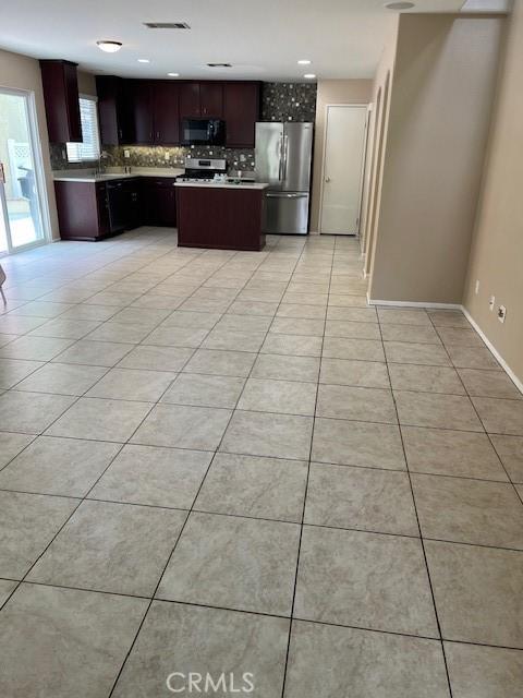 11433 Mountain View Dr Unit 62, Rancho Cucamonga, CA 91730 - kitchen with stainless steel appliances, decorative backsplash, light tile patterned floors, and a center island