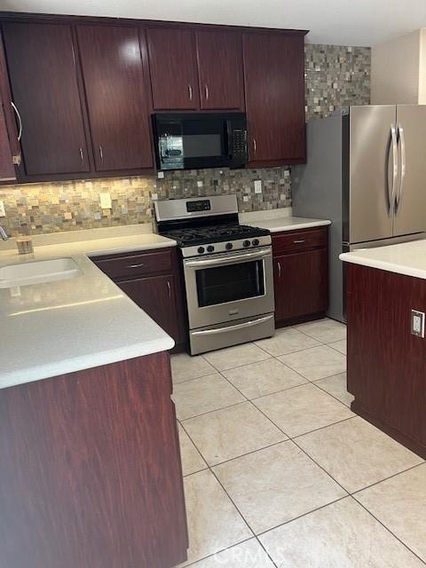11433 Mountain View Dr Unit 62, Rancho Cucamonga, CA 91730 - kitchen with appliances with stainless steel finishes, light countertops, decorative backsplash, and light tile patterned floors