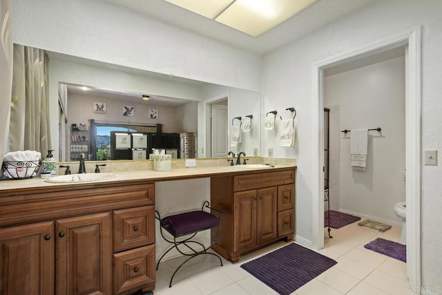 bathroom featuring double vanity, a sink, and tile patterned floors