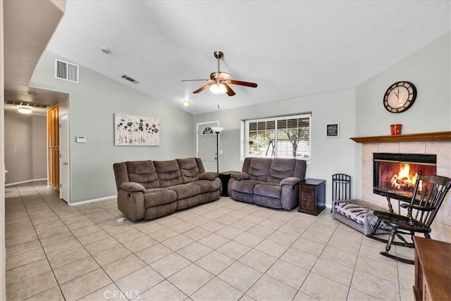 living room featuring light tile patterned floors, vaulted ceiling, ceiling fan, a fireplace, and visible vents