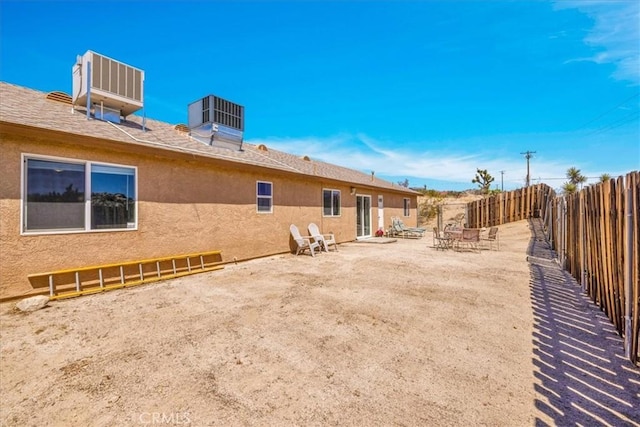 back of property with central air condition unit, stucco siding, and a fenced backyard