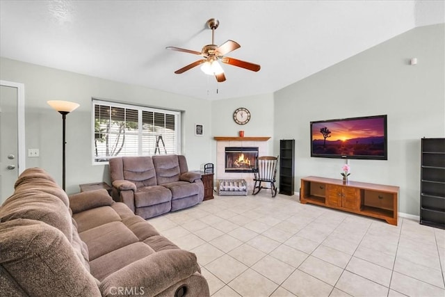 living room featuring light tile patterned floors, a ceiling fan, a tiled fireplace, and lofted ceiling