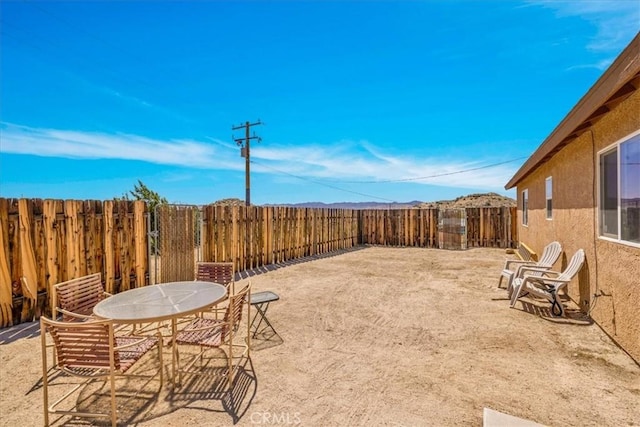 view of yard with outdoor dining space and a fenced backyard