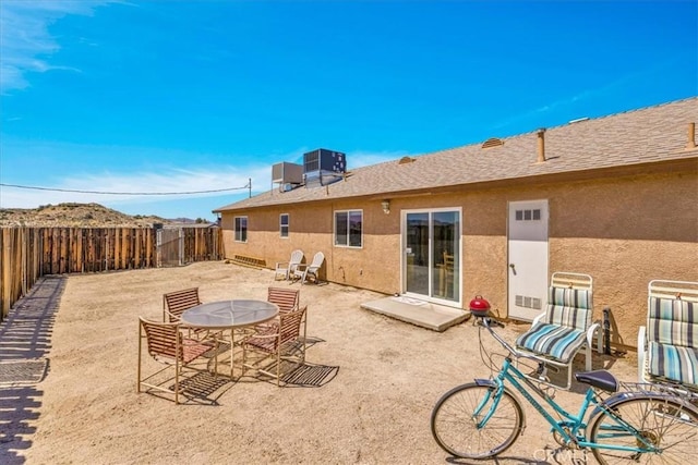 back of property with stucco siding, central AC, a patio, and a fenced backyard