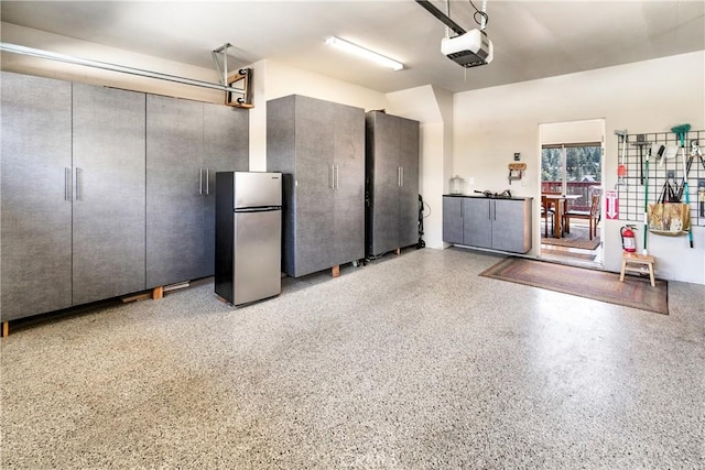 garage with freestanding refrigerator and a garage door opener