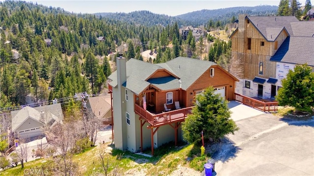 drone / aerial view with a mountain view and a forest view