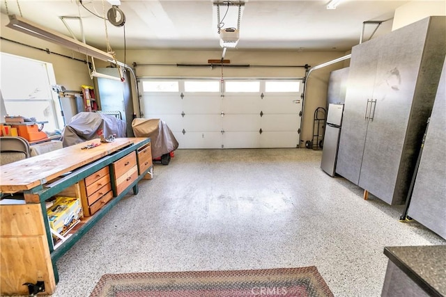 garage with a garage door opener and freestanding refrigerator