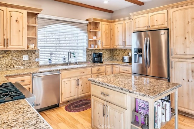 kitchen featuring open shelves, a sink, appliances with stainless steel finishes, light brown cabinets, and light wood-type flooring