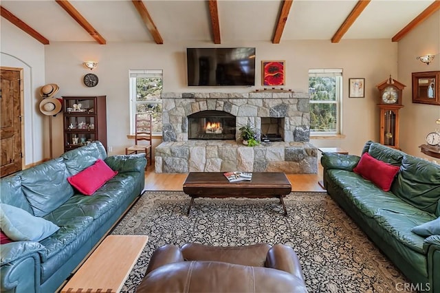 living room featuring wood finished floors, lofted ceiling with beams, and a fireplace