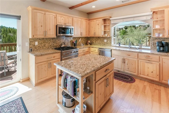 kitchen featuring a sink, stainless steel appliances, open shelves, a healthy amount of sunlight, and light brown cabinetry