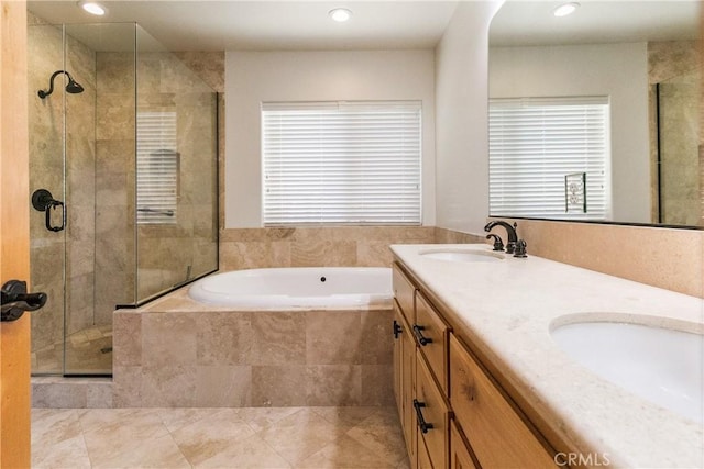 bathroom featuring a garden tub, a stall shower, double vanity, and a sink