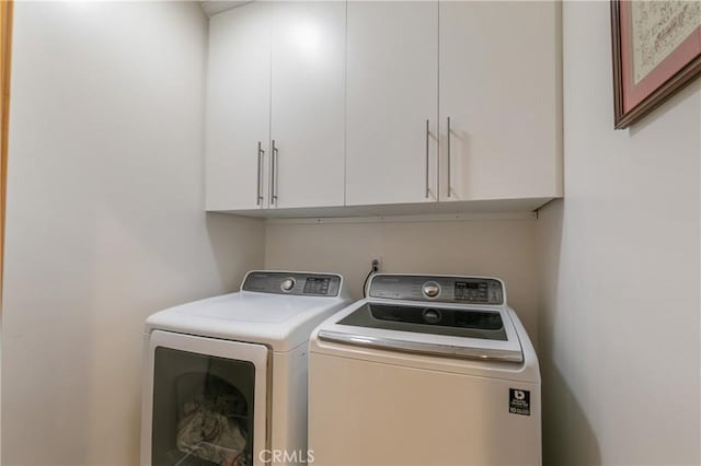 clothes washing area with cabinet space and washer and clothes dryer
