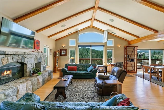living room with beamed ceiling, visible vents, wood finished floors, and a fireplace