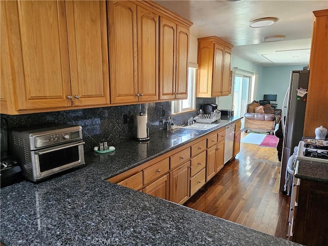 9526 Fullbright Ave, Chatsworth, CA 91311 - kitchen with white dishwasher, backsplash, gas range oven, a sink, and dark wood-style floors