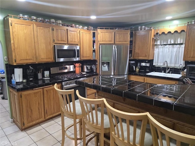 2998 Mary St, Riverside, CA 92506 - kitchen featuring light tile patterned floors, stainless steel appliances, tile countertops, and backsplash