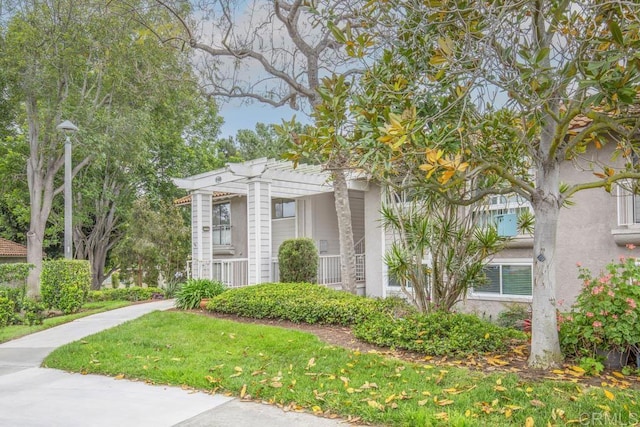 3168 Via Vis Unit B, Laguna Woods, CA 92637 - view of front of house with a pergola, stucco siding, and a front lawn