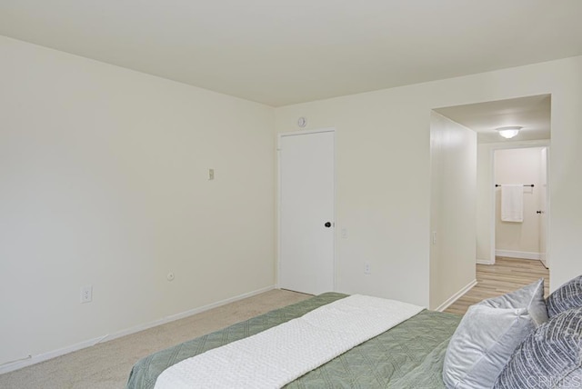 3168 Via Vis Unit B, Laguna Woods, CA 92637 - bedroom featuring light colored carpet, baseboards, and connected bathroom