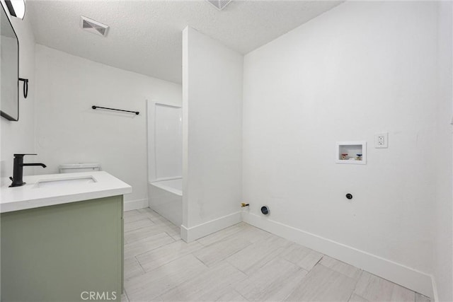 laundry room featuring washer hookup, a textured ceiling, a sink, gas dryer hookup, and visible vents
