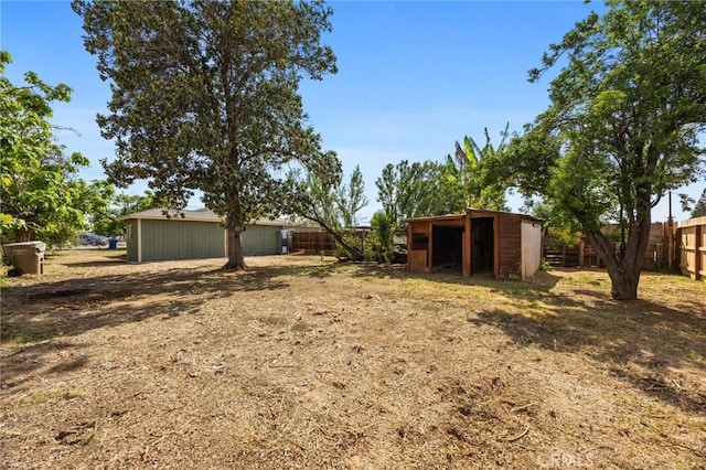 view of yard with fence and an outdoor structure