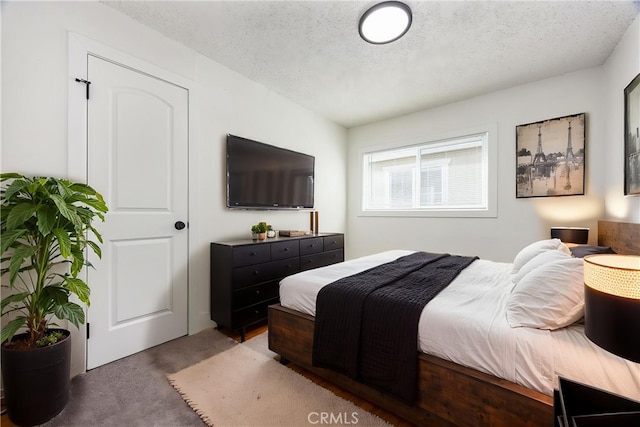 carpeted bedroom featuring a textured ceiling