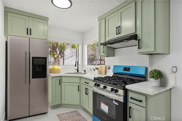 kitchen featuring a sink, stainless steel appliances, green cabinets, light countertops, and under cabinet range hood