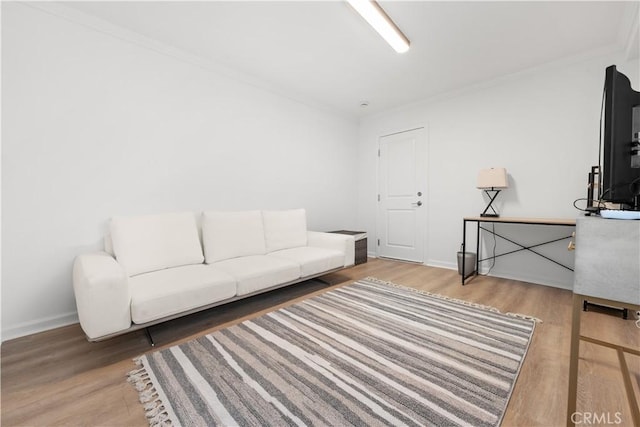 living room featuring baseboards, wood finished floors, and ornamental molding