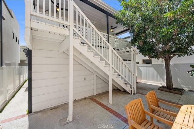 view of patio featuring ceiling fan, a fenced backyard, and stairs