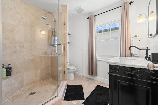 bathroom featuring toilet, visible vents, a shower stall, and vanity