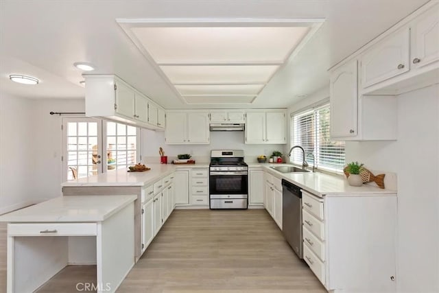 810 Hacienda Dr, Riverside, CA 92507 - kitchen with a sink, under cabinet range hood, light wood-type flooring, a peninsula, and appliances with stainless steel finishes