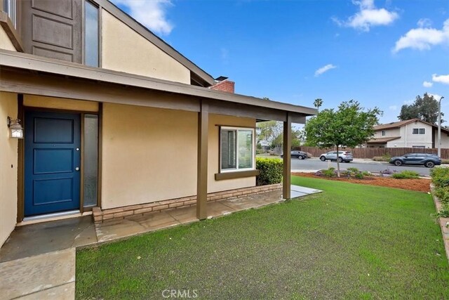 810 Hacienda Dr, Riverside, CA 92507 - view of side of home with a chimney, stucco siding, and a yard