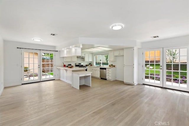810 Hacienda Dr, Riverside, CA 92507 - kitchen featuring appliances with stainless steel finishes, visible vents, light countertops, french doors, and a peninsula