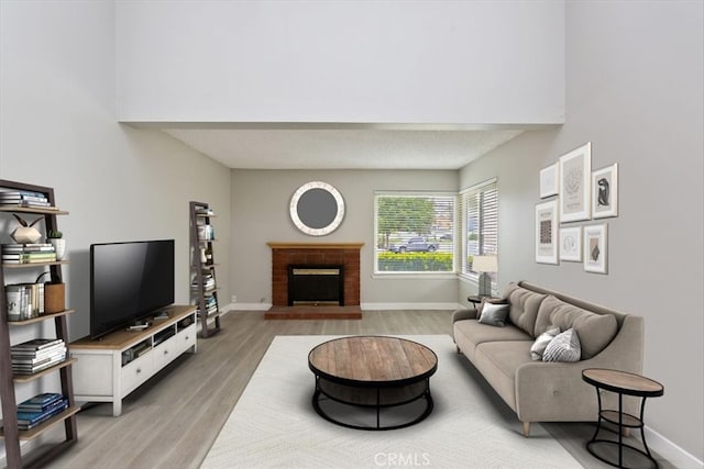 810 Hacienda Dr, Riverside, CA 92507 - living area featuring a brick fireplace, baseboards, and light wood-style floors