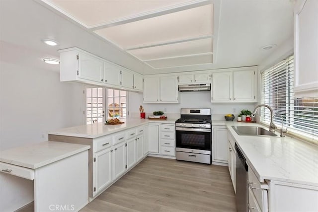810 Hacienda Dr, Riverside, CA 92507 - kitchen with a sink, under cabinet range hood, a peninsula, white cabinetry, and appliances with stainless steel finishes