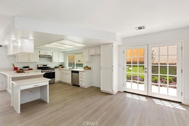810 Hacienda Dr, Riverside, CA 92507 - kitchen featuring visible vents, stainless steel appliances, light countertops, under cabinet range hood, and a peninsula