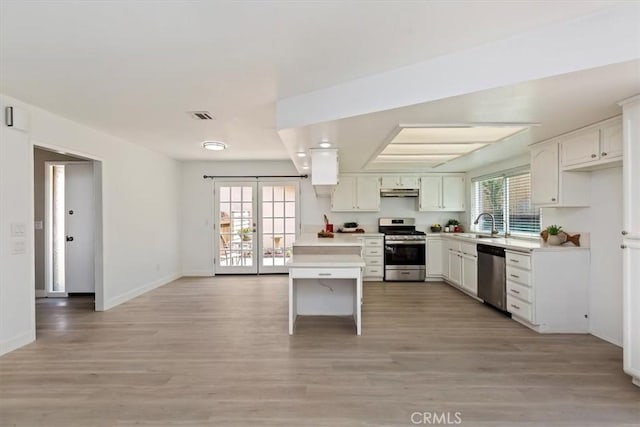 810 Hacienda Dr, Riverside, CA 92507 - kitchen featuring light wood-type flooring, stainless steel appliances, light countertops, and under cabinet range hood