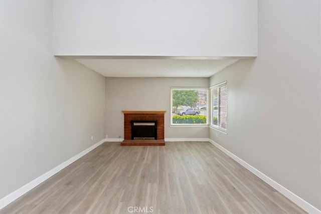 810 Hacienda Dr, Riverside, CA 92507 - unfurnished living room featuring a fireplace, light wood-style flooring, and baseboards