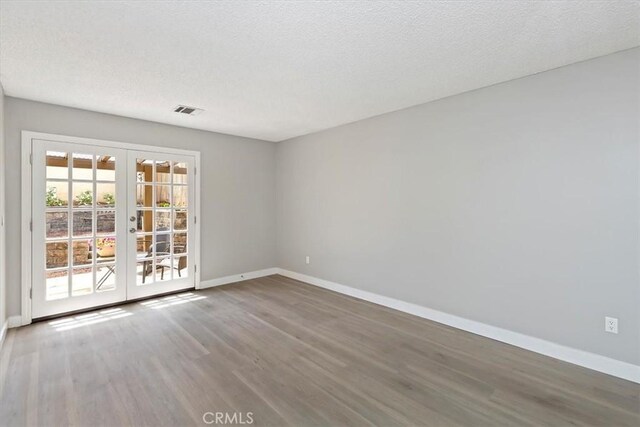 810 Hacienda Dr, Riverside, CA 92507 - unfurnished room with visible vents, baseboards, a textured ceiling, french doors, and wood finished floors