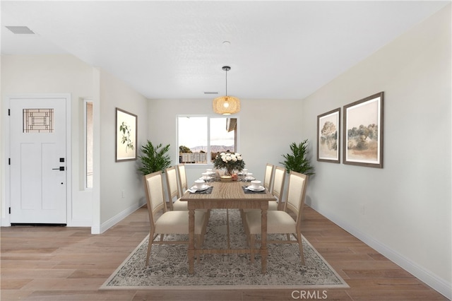dining room with baseboards, light wood-type flooring, and visible vents