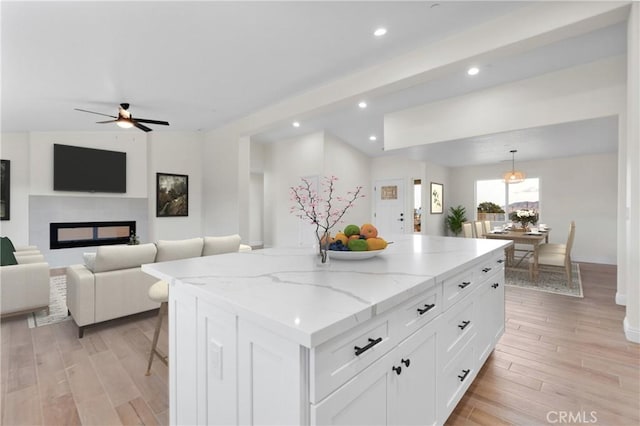 kitchen featuring a center island, recessed lighting, white cabinets, and light wood-type flooring