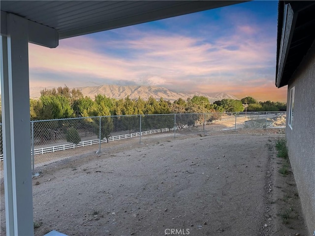 view of yard featuring a mountain view and fence