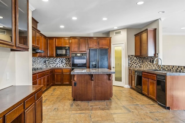 kitchen with backsplash, visible vents, a sink, and black appliances