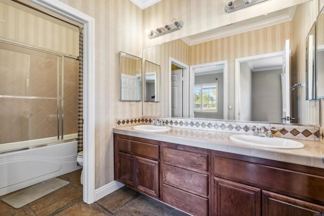 bathroom with crown molding, a sink, and wallpapered walls