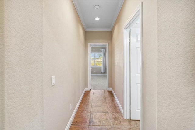 hall featuring crown molding, a textured wall, and baseboards